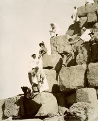 Touristes gravissant les pyramides avec des guides indigènes